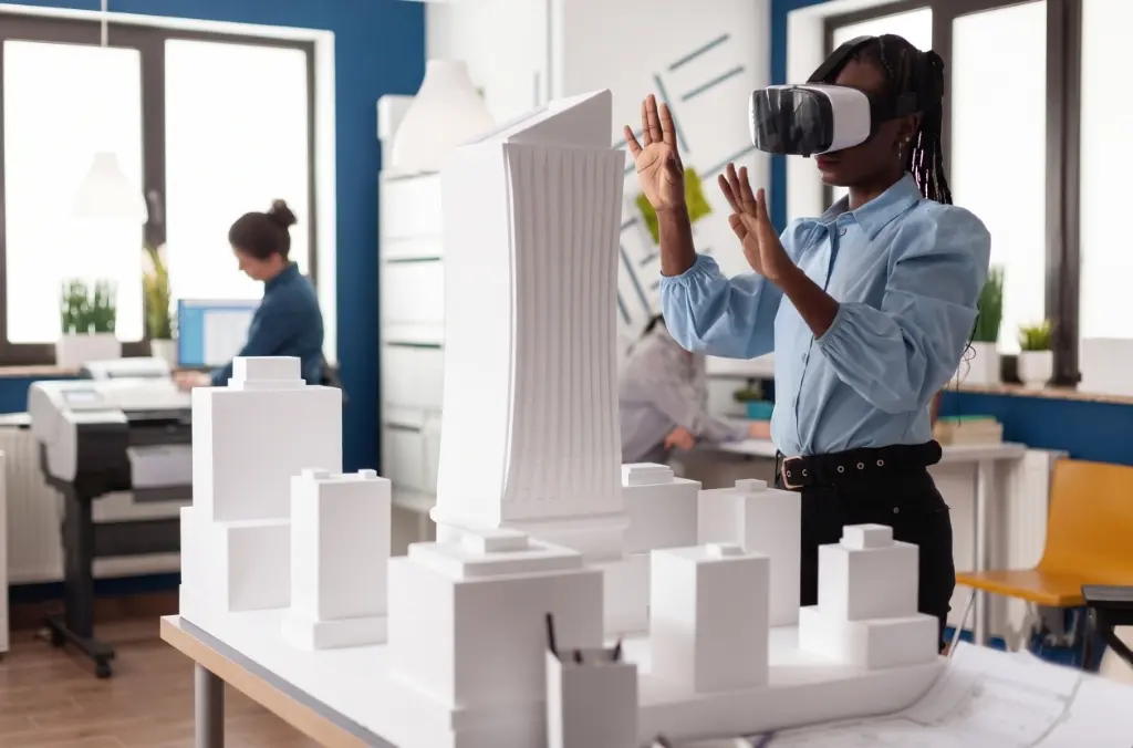 Architect wearing a VR headset beside a white scale model of a city block